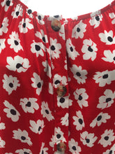 Load image into Gallery viewer, Small white flowers with black centers just pop on this gorgeous true red long sleeve top. The feminine touches create a romantic top with a scoop neckline and a row of button closures, as well as ruffled cuffs. A lightweight material, this will keep you cool in the warmer days and warm when there is a slight chill. This is the choice of top to pair with crisp white bottoms and effortlessly goes well with jeans.
