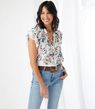 Load image into Gallery viewer, The feminine romantic style of this top is enhanced by pintuck pleating at the shoulders, ruffled neckline details, and small-scale florals. Wear it with your favorite jean and stylish sandal for an on-trend look. Colors- Primarily white with vibrant blue, green, yellow and pink flower print.