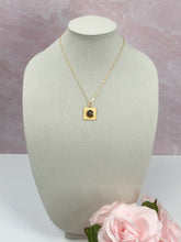 Load image into Gallery viewer, If you want a stylish piece of jewelry that is as unique as you are, our Skyla necklace fits that category. This dainty iridescent vintage CC button sits beautifully on a square gold pendant setting and hangs from a shiny gold necklace. The iridescent colors in the button flash with every move and catches the eye. 