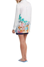 Load image into Gallery viewer, How absolutely darling and unique is our Janene top?! With the printed picture of ladies at the beach, it just makes one long for summer days and beach/pool time. This chic button-front tunic top serves up all the fashionable extras we love while keeping it easy, breezy, and effortless to wear. The 30' length makes it just right for endless outfit options that you can wear from day to night and always make the best-dressed list.