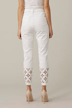 Load image into Gallery viewer, This slim leg capri designed by Joseph Ribkoff has a style that is not only unique but highly fashionable. The floral cut-out pattern at the cuff of each leg is enhanced by sparkling crystals that catch the eye! A slight fray at the bottom of each leg gives this spectacular jean an edge. The Isla is not only elegant but also fun at the same time. A pure white jean, this capri will pair beautifully with anything in your closet!