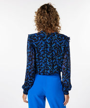 Load image into Gallery viewer, A gorgeous pop of all over blue in an animal print is striking on the Wilda Wild Celebration Blouse. The Wilda has a round neckline, decorative ruffles on the shoulders and smocked cuffs. Pair with a pair of faux leather or black pants or your favorite denim and boots and you'll be a fashionista!