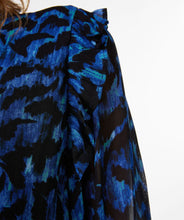 Load image into Gallery viewer, A gorgeous pop of all over blue in an animal print is striking on the Wilda Wild Celebration Blouse. The Wilda has a round neckline, decorative ruffles on the shoulders and smocked cuffs. Pair with a pair of faux leather or black pants or your favorite denim and boots and you'll be a fashionista!