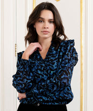 Load image into Gallery viewer, A gorgeous pop of all over blue in an animal print is striking on the Wilda Wild Celebration Blouse. The Wilda has a round neckline, decorative ruffles on the shoulders and smocked cuffs. Pair with a pair of faux leather or black pants or your favorite denim and boots and you'll be a fashionista!