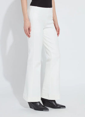 Model wearing white pants and black boots against a white background.