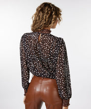Load image into Gallery viewer, This brown, smocked long sleeve blouse, featuring swirling circles known as &quot;Animal Steps,&quot; is a fashionable piece that can be dressed up or down depending on the occasion. Its unique design offers a chic and stylish look. Color-Brown, black, brown. Button back closure. Smocked neck and sleeves. Slightly sheer. Suggest wearing a black bra or black cami underneath.
