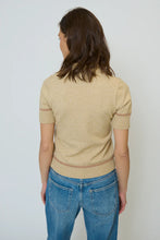 Load image into Gallery viewer, Woman wearing a short sleeve brown polo sweater with contrasting faux leather and blue jeans against a neural background.
