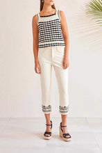 Load image into Gallery viewer, Consider a classic sand-colored (ecru) jean enhanced with intricate black, silver and gold eye-catching embroidery at the hems for a chic and timeless appearance. The cropped denim is an ideal choice for the spring/summer seasons and matches perfectly with our Ecru Cotton Crochet Tank featuring similar colors and designs, or a simple black top.
