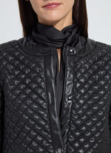 Load image into Gallery viewer, Close-up of model wearing a black quilted jacket.

