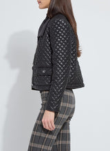 Load image into Gallery viewer, Model wearing a black quilted jacket over a black blouse and plaid pants against a white background.
