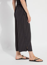Load image into Gallery viewer, Black pinstripe pants and black sandals worn by a model on a white background.
