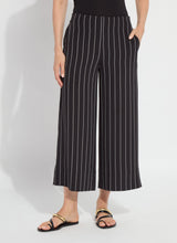 Load image into Gallery viewer, Model wearing black pinstripe pants  and black sandals on a white background.
