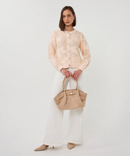 Load image into Gallery viewer, Model wearing a peach sweater, white pants and beige heels, carrying a cappuccino colored suede bag against a white background.
