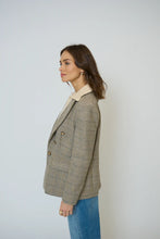 Load image into Gallery viewer, Woman wearing a plaid blazer with blue jeans against a plain background.
