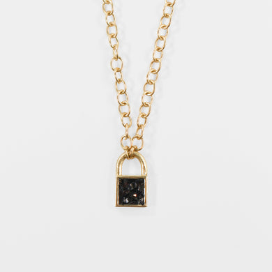Crafted from sterling silver with 18k gold micron plating and embedded with crushed black diamonds, this chic lock necklace radiates a dazzling sparkle in light. An accompanying 16