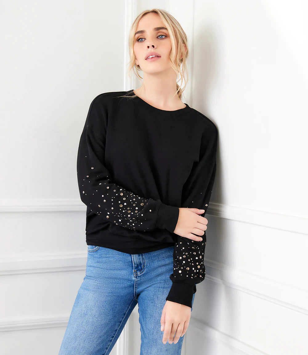 This sweatshirt is the perfect blend of comfort and sophistication. It features exquisite embellishments on each sleeve that catch the light with every movement, creating an eye-catching silhouette.  Color-Black. Long sleeves. Crew neckline. Fabric-Fleece Knit: 69% Modal. 26% Cotton. 5% Spandex. Care- Hand wash cold. Do not bleach. Hang to dry.