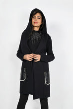 Load image into Gallery viewer, A stunningly unique piece, the Belen hooded cardigan adds a sophisticated finish to any look. Crafted with faux leather pockets and adorned with white pearl embellishments, it&#39;s guaranteed to turn heads.  Color- Black. Hood. Pearl embellishments. Faux leather pockets. Fabric -50% Rayon, 28% Polyester. 22% Nylon.
