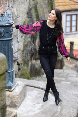 This Frank Lyman garment features a semi-sheer sleeve design in a bold magenta hue, adorned with an intricate floral pattern. Tailored with a stretchy fabric to provide a relaxed fit, the McKenna top pairs perfectly with jeans or trousers.    Pair with our Bettany Black and Magenta Painted Foral Denim Jean - Frank Lyman 233886U for a perfect look.  Color - Magenta, bright coral, pink and black. Billowy sleeves. Semi sheer sleeves. No pockets. No zipper.