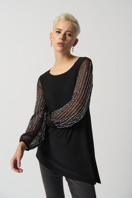 This luxurious tunic is crafted from a silky knit fabric, with mesh puff sleeves for a touch of drama. The asymmetrical design is flattering and feminine, while the beading detail adds a touch of glamour.  Color - Black. Silky knit with mesh. Beading on sleeves. Boat neckline. Puff sleeves. Asymmetrical hem. Unlined.