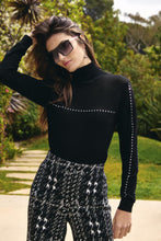 Load image into Gallery viewer, Our Baila in classic black, is a sophisticated lightweight sweater turtleneck designed to enhance any wardrobe.&nbsp; Its elegant silver embellished detailing brings a touch of sparkle and glamour, ideal for both casual and formal settings. This versatile turtleneck pairs effortlessly with everything from denim to skirts.
