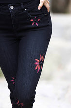 Load image into Gallery viewer, These black straight leg jeans crafted from exceptional denim feature eye-catching hand-painted motifs of bright magenta flowers, which are further accented with sequins and rhinestones for a dazzling finish. Make a bold style statement and stand out from the crowd in these extraordinary jeans.  Color- Black and magenta. Slim leg design. Painted floral designs with sequin and rhinestones. Floral designs on front side only. Five functional pockets. Zipper and button closure.
