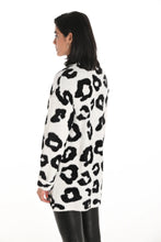 Load image into Gallery viewer, Woman wearing a white coat with black leopard print pattern and black pants against a white background.

