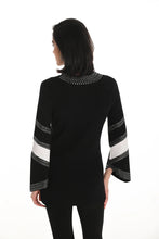 Load image into Gallery viewer, Woman wearing a long sweater with white and black patterned sleeves with crystal embellishments and black pants against a white background.
