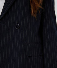 Load image into Gallery viewer, Close-up of navy pinstripe blazer with a button and flap pocket detail.
