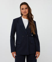 Load image into Gallery viewer, Woman wearing a navy pinstripe suit  and white top against a white background.
