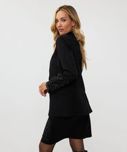 Load image into Gallery viewer, Make a stylish and confident statement with our EsQualo blazer. This timeless black blazer features exquisite beaded detailing on both sleeves, adding a touch of elegance to any outfit. This must-have piece belongs in every fashion-savvy closet and will remain a staple for years to come. Pictured paired with our Senia Skirt Embellishment in Black - EsQualo W2405720. A perfect match!
