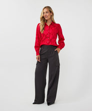 Load image into Gallery viewer, Featuring a raised floral pattern and a bold red hue, the Brandee Blouse 2tone Flower Jacquard by EsQualo is a must-have for those looking to make a statement. The thicker fabric is perfect for colder days, and can easily be dressed up with a skirt, trousers, or even your favorite denim. Don&#39;t miss out on leaving a lasting impression with this chic and unforgettable blouse.
