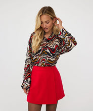 Load image into Gallery viewer, This stylish blouse features a 100% viscose fabric in a cheerful waves print. The vibrant red, black, off white, gold, and mint colors create a versatile style that pairs perfectly with your favorite bottoms. Complete the look by pairing it with a matching red or black skirt or pant.
