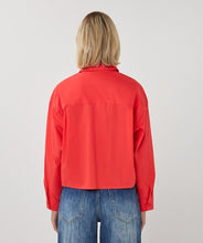 Load image into Gallery viewer, Woman wearing a red shirt and blue jeans on a white background.
