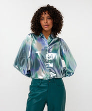 Load image into Gallery viewer, Model wearing a teal, blue and silver blouse with teal pants against a white background.
