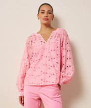Load image into Gallery viewer, Woman wearing a pink eyelit blouse and pink pants against a beige background.
