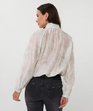 Load image into Gallery viewer, Woman wearing an off-white blouse and dark jeans against a white background.
