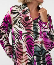 Load image into Gallery viewer, Woman wearing a vibrant, multicolored zebra print shirt against a white background.
