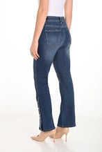 Load image into Gallery viewer, Woman wearing white top, blue ankle length jeans with button detailing and beige heels against a white background.
