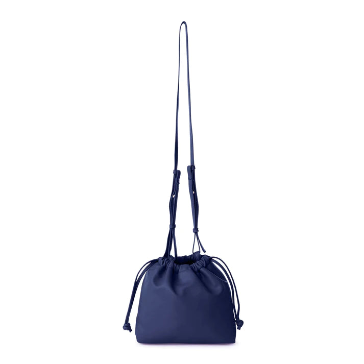 This stylish bucket bag is spacious, perfect for carrying all the essentials when you're on the go! It also features a removable and adjustable strap for easy carrying. Constructed from ultra-soft vegan leather, this bag is sure to have heads turning!  Color- Sapphire. Removable strap. Interior slit pocket. Vegan leather. Drawstring closure. Measurements--11.5’’ x 3’‘x 6’’ Chain 24.5” long.