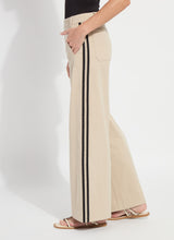 Load image into Gallery viewer, Model wearing khaki wide-leg pants with black stripes and strap sandals against a white background.
