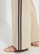 Load image into Gallery viewer, Model wearing khaki wide-leg pants with black stripes and strap sandals against a white background.
