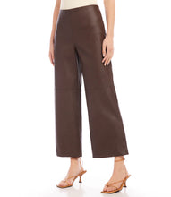 Load image into Gallery viewer, Introducing our contemporary and sustainable Cropped Vegan Leather Pants, tailored for fashion-conscious individuals who prioritize the environment. Constructed from premium materials, these pants offer the same modern look of leather while ensuring cruelty free.  Color- Brown. Wide-leg. Elasticized waistband. Invisible side zipper. Fabric - 50% Viscose 50% Polyurethane.
