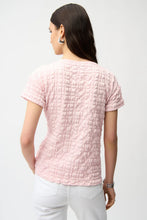 Load image into Gallery viewer, Woman wearing a short sleeve pink textured top and white pant on a white background.
