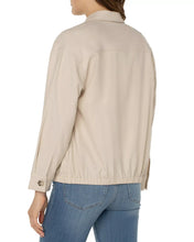 Load image into Gallery viewer, Woman wearing a tan jacket and blue jeans against a white background.
