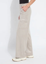Load image into Gallery viewer, Model wearing soft taupe shiny cargo pants, black top and white sneakers against a white background.
