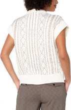 Load image into Gallery viewer, Model wearing a cap sleeve cream half zipper sweater with camel stitching throughout and brown check pants against a white background.
