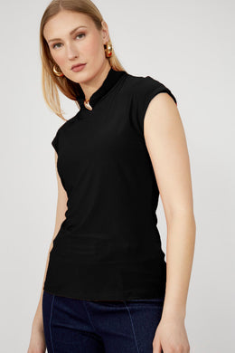 Woman wearing a black cap sleeve top and jean against a white background.