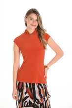 Load image into Gallery viewer, Woman wearing an orange top with a patterned skirt against a white background.
