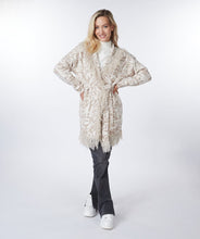 Load image into Gallery viewer, This animal print cardigan with fringe detailing is classic and stylish. The cardigan features a belted waist that adds visual interest. Whether you dress it up or pair it with denim, it&#39;s the ideal accessory for cooler weather where a jacket or coat might be too heavy.  Color-Bisquit; Light tan and white. Animal print. Belted closure. Fringe detailing all around.  Longer design.  Fabric - 85% Acrylic. 15% Polyester.
