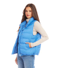 Load image into Gallery viewer, This versatile outerwear option features convenient snaps and a zipper for easy wear and adds just the right amount of insulation when needed. Stand out in style and step into the weather with this cute and feminine vest. Color - Chambray. Length: 24 5/8 inches (size M) Stand collar. Sleeveless. Drawcord-toggle waist. Fabric - Puffer: 100% Nylon.
